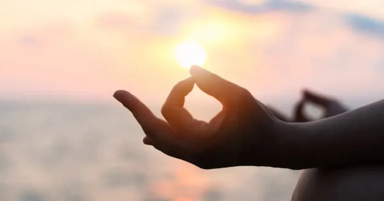 Meditation Mantras: Unlocking Peace and Focus in Life 2024 2 Meditation Mantras: a person is mediating. On the background is a sunset
