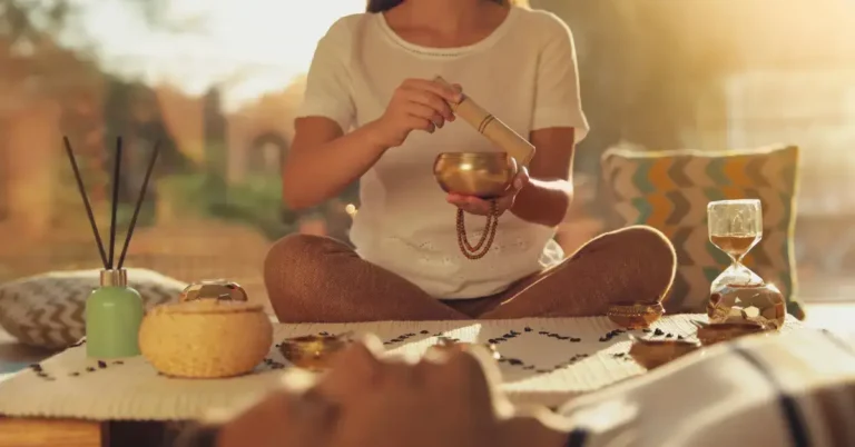 Meditation for Emotional Healing: Guide to Inner Peace 2024 3 Meditation for Emotional Healing: a person lie and meditate. In the back a woman is sitting with a singing bowl