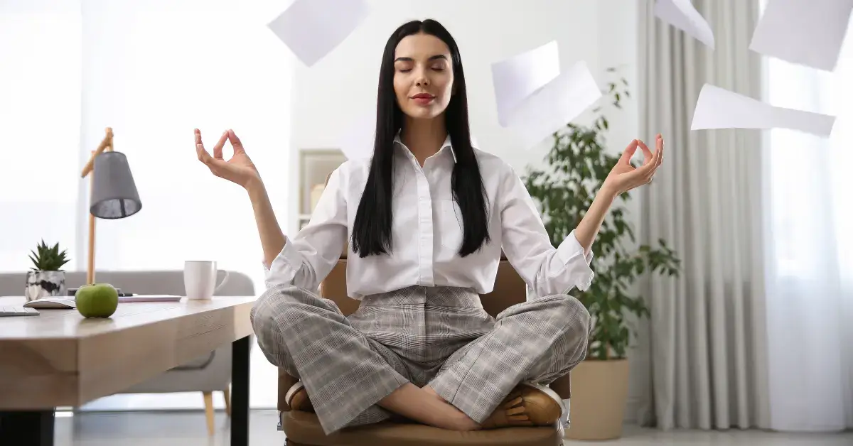 Meditation for Stress Relief at Work: a woman is sitting in the office and meditate on her chair.
