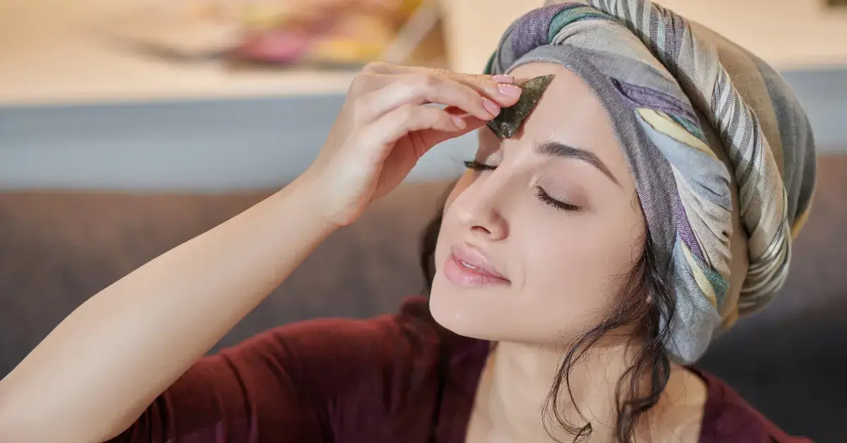 Third Eye Meaning: a woman holds a stone on her forehead